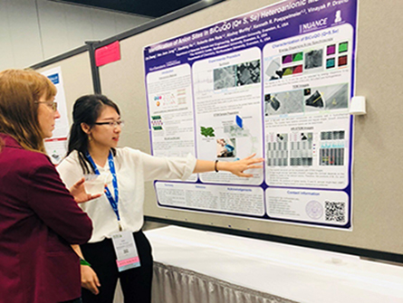 Chi Zhang discussing poster with conference attendee