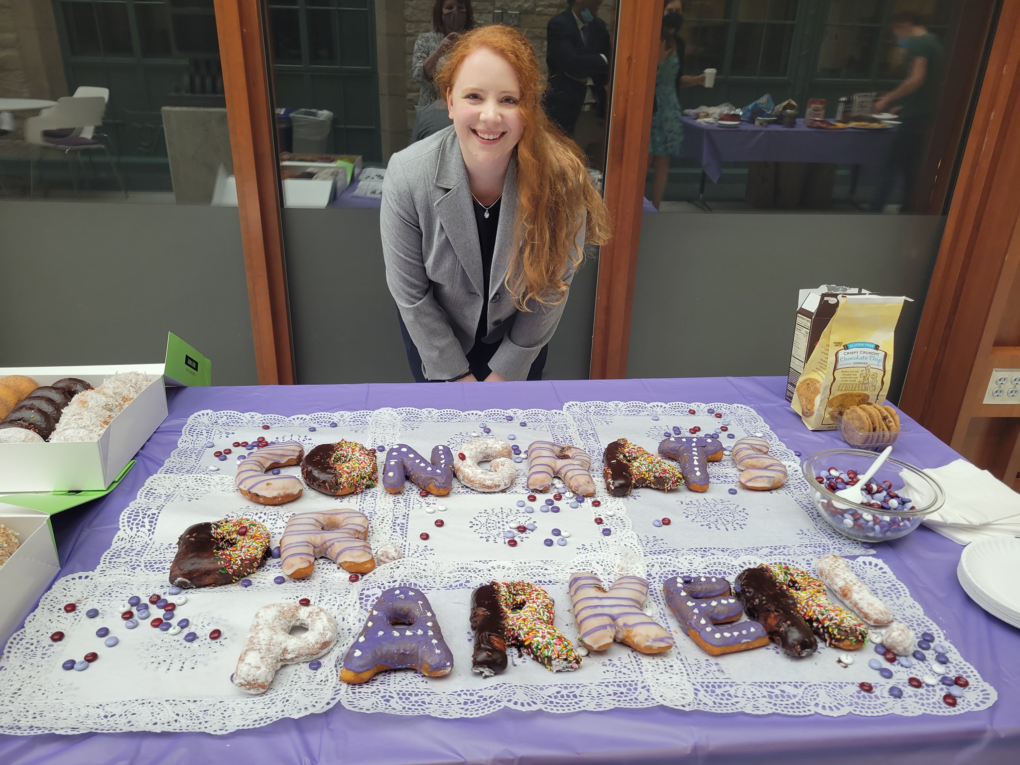 Dr. Kelly Parker stands in front of celebratory donuts after successfully defending.