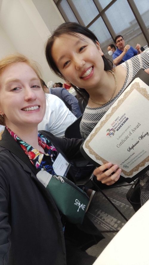 Stephanie Wang and Tirzah Abbott smiling with Stephanie's award in hand
